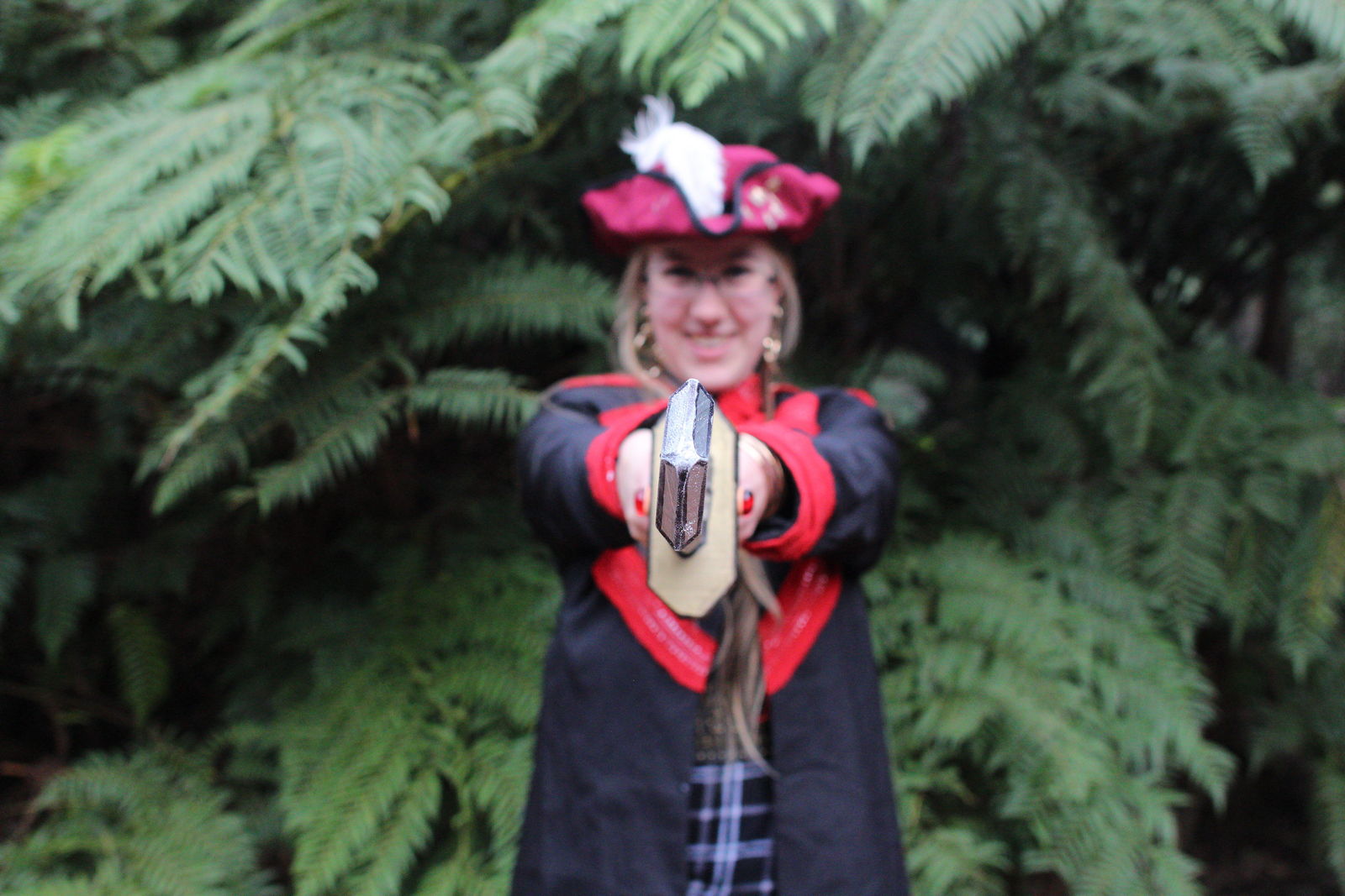 In pirate costume, pointing a sword